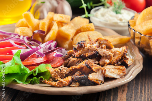 Greek gyros dish with french fries and vegetables photo
