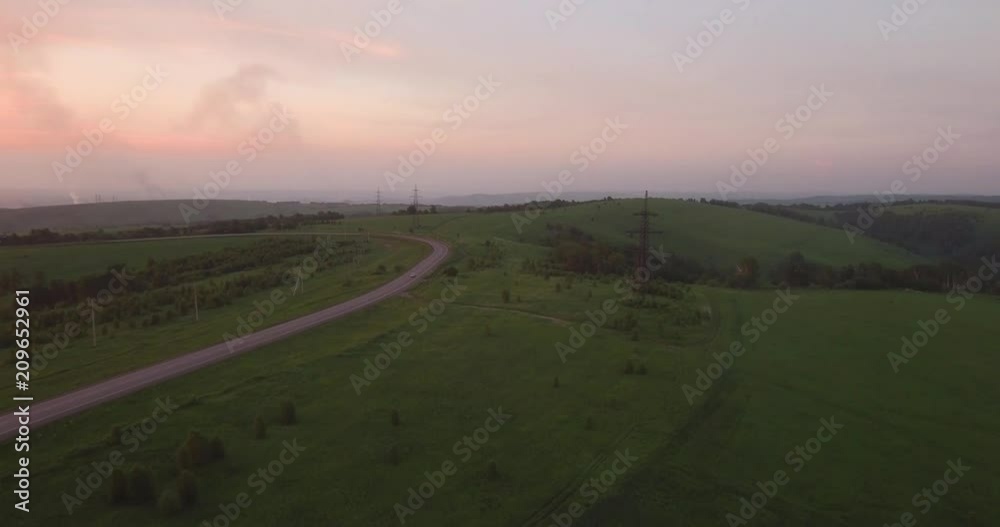 AERIAL view. long and winding road passing through green hills with countryside scenery. air pollution around the industrial city. 4K AERIAL view. long and winding road passing through green hills with countryside scenery. air pollution around the industrial city. 4K