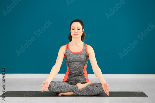 Beautiful woman practicing yoga indoors