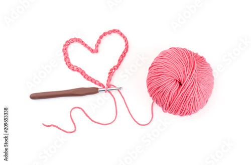 Ball of knitting yarn with crochet hook on white background photo