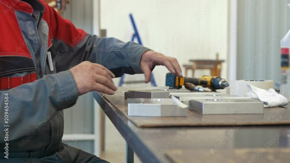 Man working with metal object for manufacturing industrial CNC machinery Man working with metal object for manufacturing industrial CNC machinery