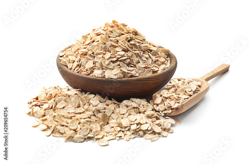 Bowl and scoop with raw oatmeal on white background