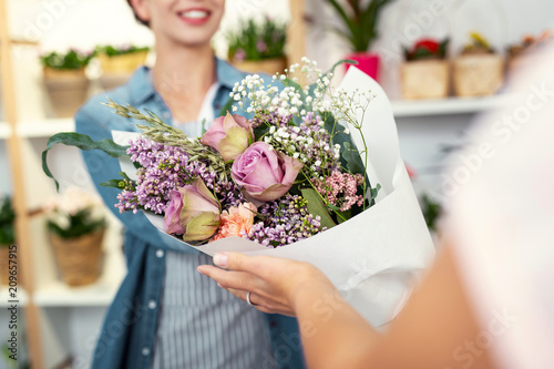 Floristic masterpiece. Selective focus of a big beautiful bouquet being in given to a customer of the flower shop photo