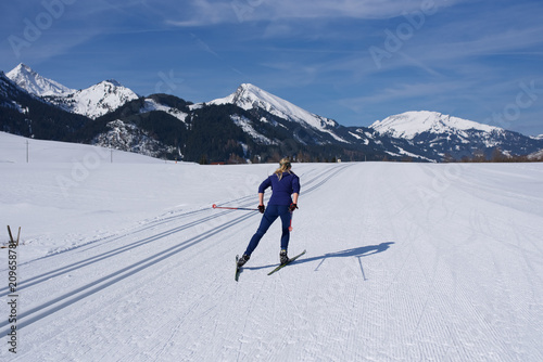 Skilangläufer vor Alpenbergen im Winter beim Skifahren7