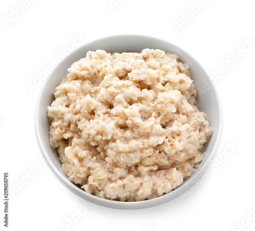 Tasty oatmeal in bowl on white background