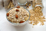 Bowl with raw oatmeal and nuts on table