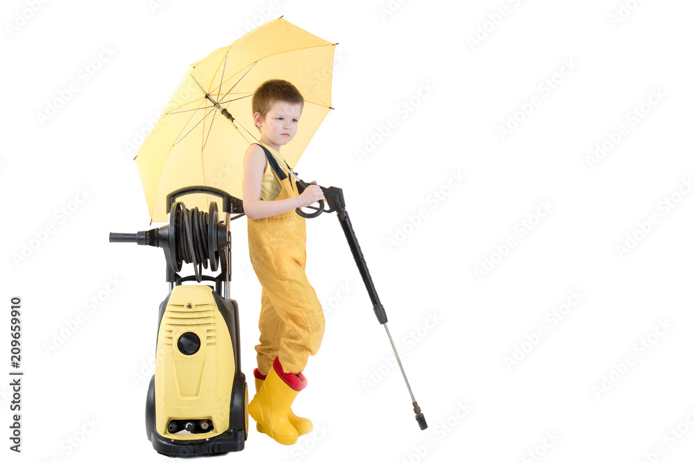 Happy child in yellow overalls and boots with high pressure washer serves client boy on toy car under umbrella. Concept of family business. White background