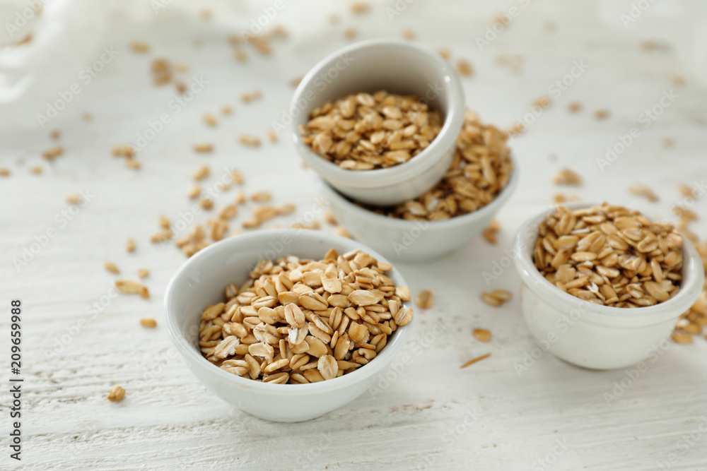 Bowls with raw oatmeal on light background Bowls with raw oatmeal on light background