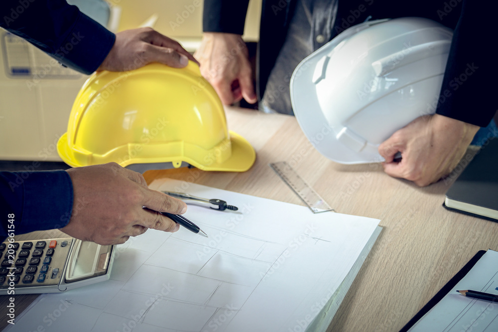 Engineer and architect working document about progress of work schedule and construction drawing on the site Engineer and architect working document about progress of work schedule and construction drawing on the site