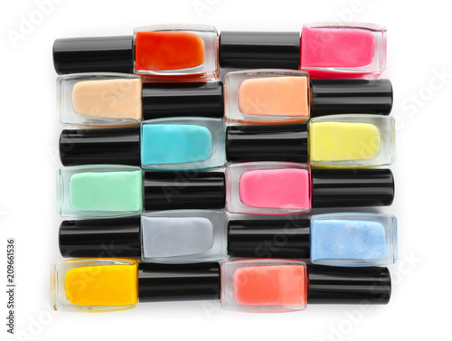 Bottles of colorful nail polish on white background  flat lay