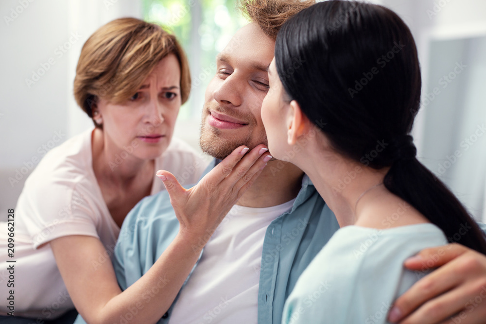 I need attention. Sad aged woman touching her sons cheek while needing his attention I need attention. Sad aged woman touching her sons cheek while needing his attention
