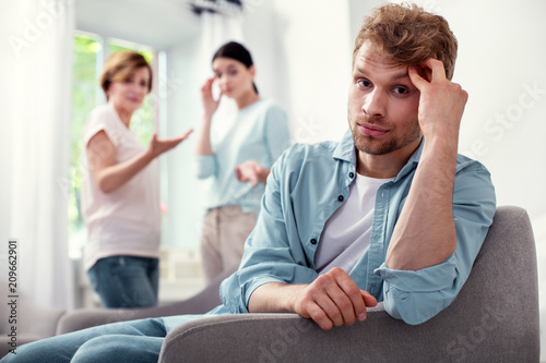 So depressed. Unhappy bearded man holding his forehead while thinking about his family problems