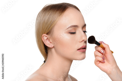 Beauty portrait of a smiling beautiful half naked woman posing with make-up brushes