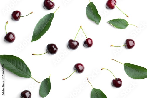 Sweet cherries and green leaves on white background