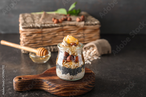 Glass jar with delicious oatmeal dessert on table