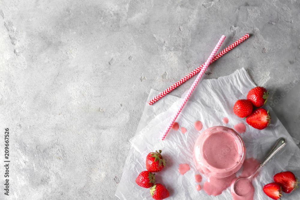 Glass jar with tasty strawberry smoothie on light table Glass jar with tasty strawberry smoothie on light table