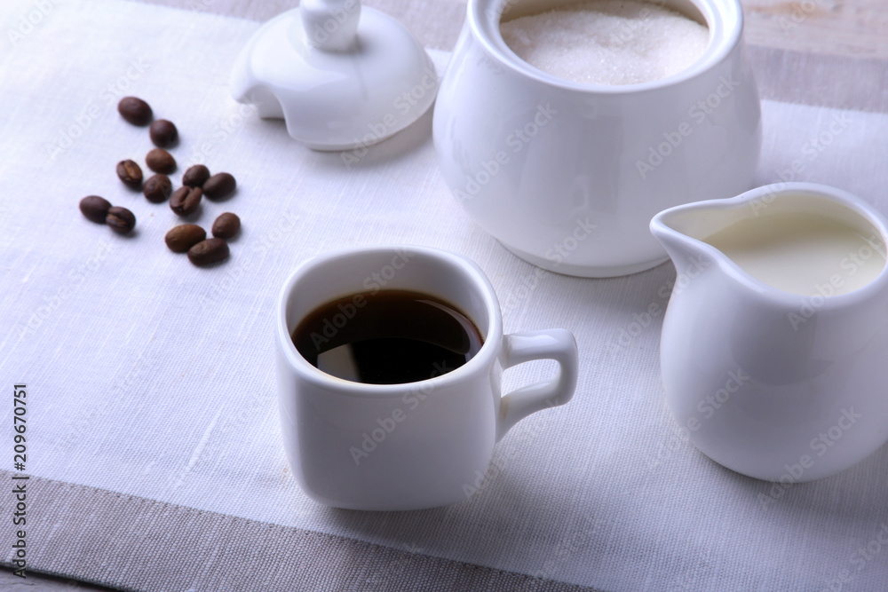 Cup of hot coffee espresso, coffee beans, jug of milk, and bowl with sugar on white background for copy space. Coffee concept. Cup of hot coffee espresso, coffee beans, jug of milk, and bowl with sugar on white background for copy space. Coffee concept.