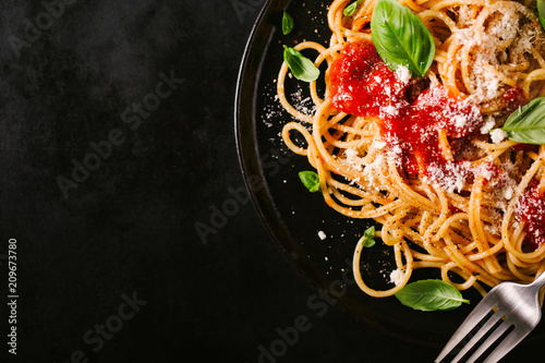 Photo Dark plate with italian spaghetti on dark