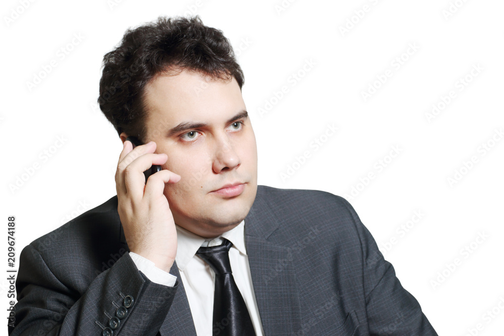Serious young businessman in suit calls by mobile phone isolated on white Serious young businessman in suit calls by mobile phone isolated on white