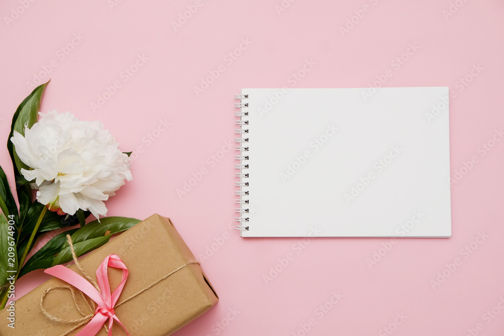 Composition with flowers, gift and notebook on pink background. Mock up for your design. Flat lay. Composition with flowers, gift and notebook on pink background. Mock up for your design. Flat lay.