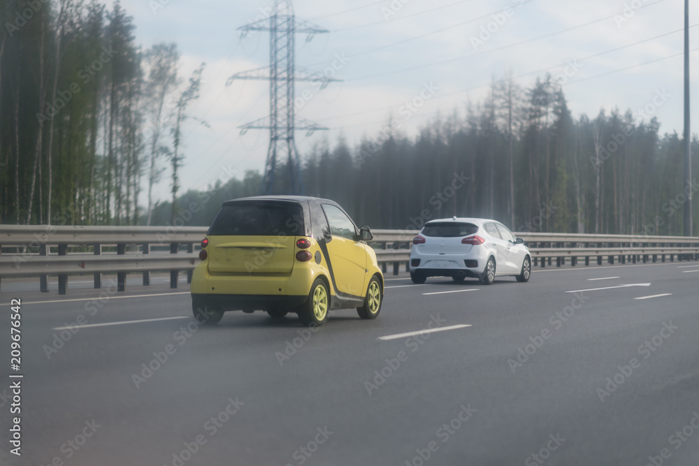 Obraz premium Traffic on the highway with metal safety barrier. two cars on the road