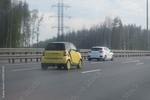 Traffic on the highway with metal safety barrier. two cars on the road