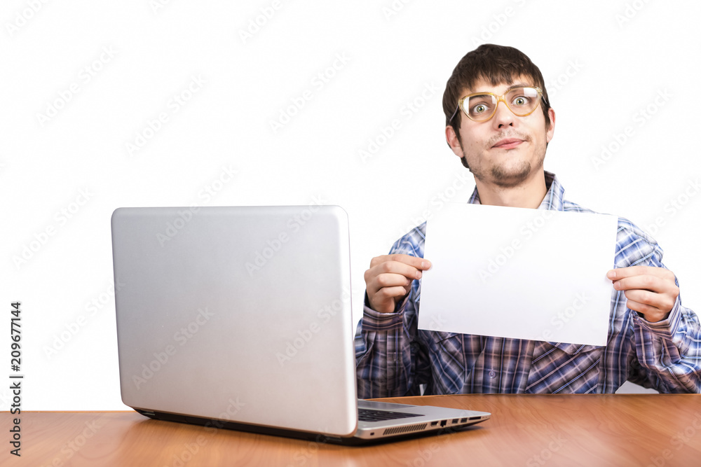 cheerful guy in glasses sits at table with computer computer on white background cheerful guy in glasses sits at table with computer computer on white background