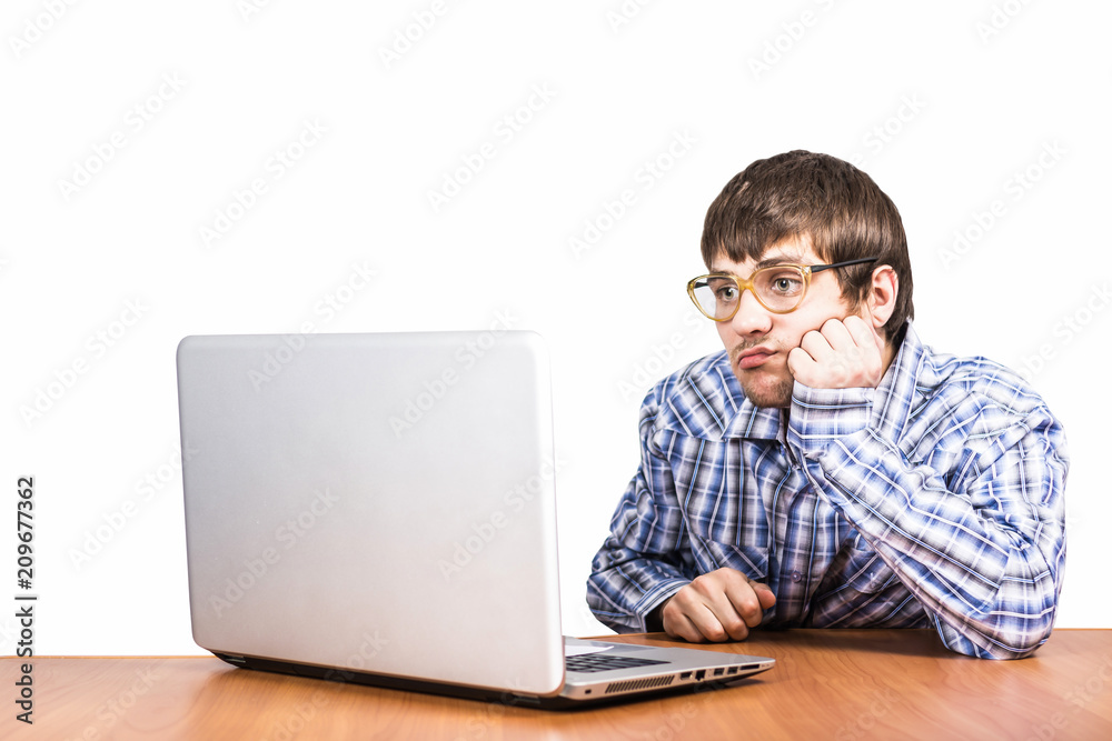 sad guy with glasses sitting at table with computer computer sad guy with glasses sitting at table with computer computer