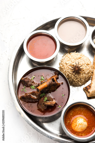 Motton Thali OR Gosht/Lamb platter is Indian/asian non veg lunch/dinner menu consists of meat, egg curry with chapati ,rice, salad and sweet Gulab Jamun photo