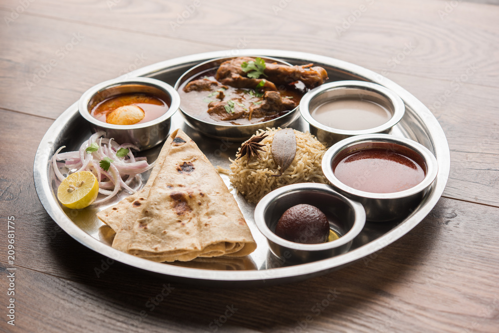 Kolhapuri chicken Thali is a popular Indian/asian food platter consists of poultry meat, egg curry with chapati ,rice, salad and sweet Gulab Jamun Kolhapuri chicken Thali is a popular Indian/asian food platter consists of poultry meat, egg curry with chapati ,rice, salad and sweet Gulab Jamun