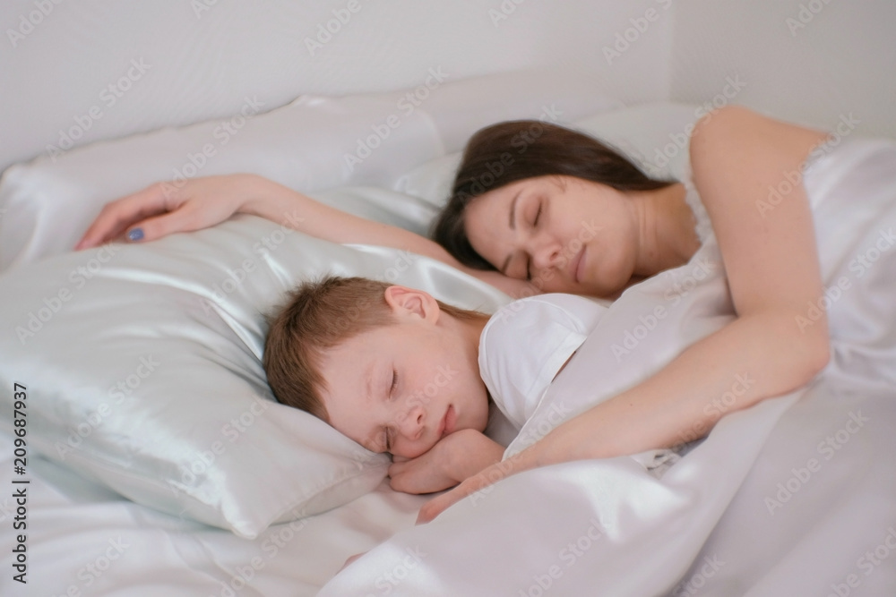 Mom and son sleeping together. Mom hugging her son. Stock Photo Adobe