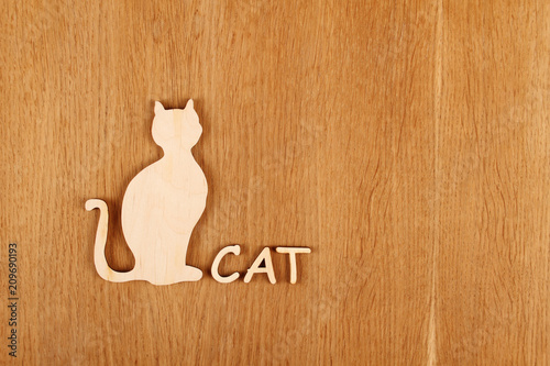 Wooden silhouette of a cat on a wooden surface. Background photo