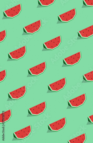Seamless pattern of watermelon slices with seeds on the green background.
