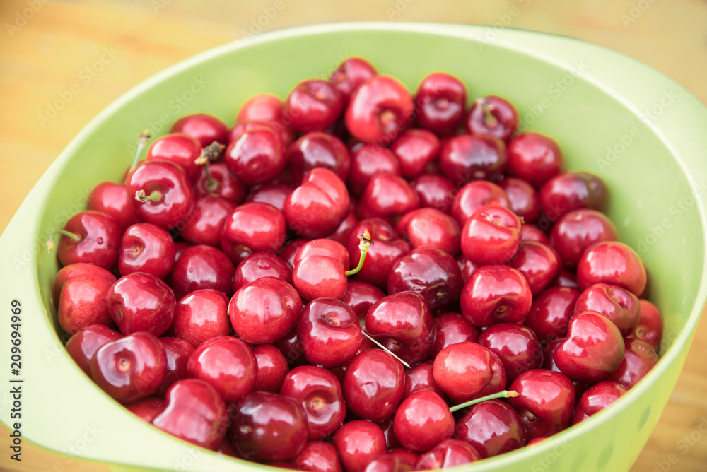 red cherries in a green bowl, healthy organic fruits freshly harvested from the orchard red cherries in a green bowl, healthy organic fruits freshly harvested from the orchard