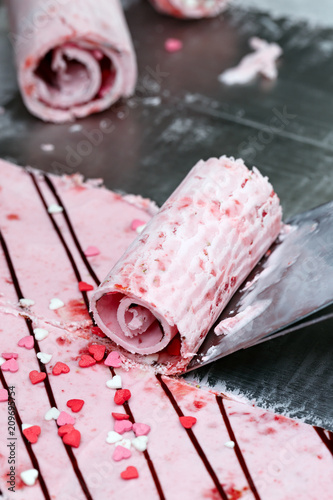 Thai roll ice cream is made by hand on the freezer. Sweet dessert made from natural berries and ingredients. The process of making food.