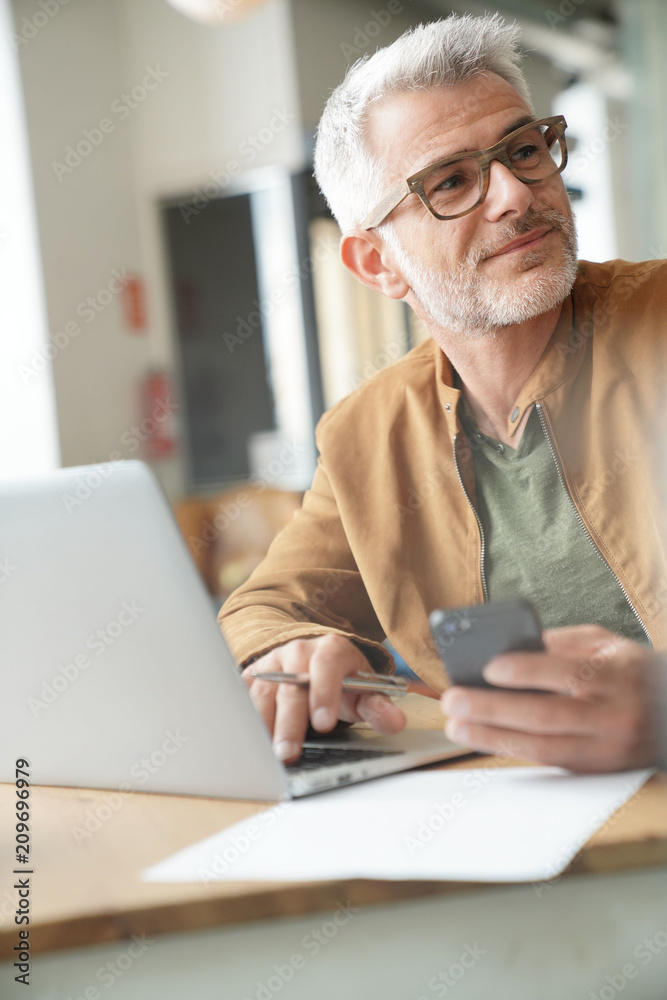Man in trendy coffee shop working on laptop computer Man in trendy coffee shop working on laptop computer