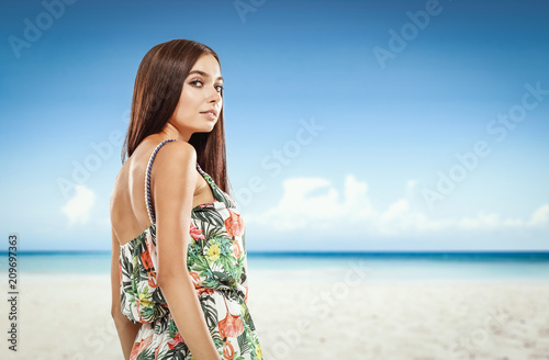 Beautiful young woman on the beach. Blurry beach and ocean background.