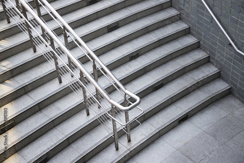 stainless steel handrail on stone stair step.