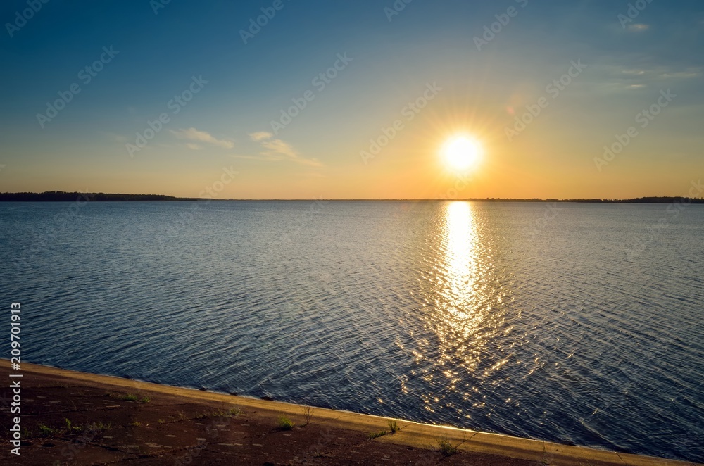 Sunny summer landscape. Beautiful sunset on the lake.