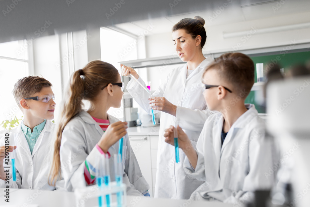 education, science and children concept - teacher and kids or students with test tubes studying chemistry at school laboratory education, science and children concept - teacher and kids or students with test tubes studying chemistry at school laboratory