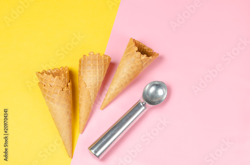 Ice cream waffle cones over sweet pink and light yellow background with scoop and copy space for text, logo or wordings insertion or decoration, summer cold sweets