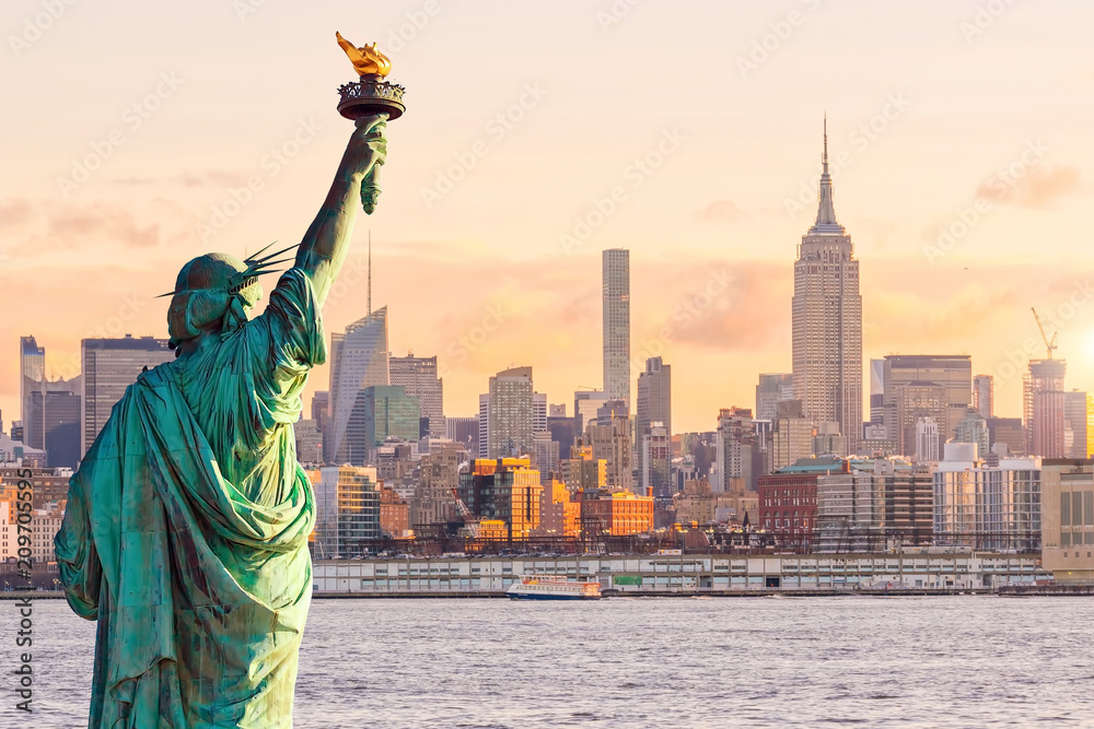 Statue Liberty and New York city skyline at sunset
