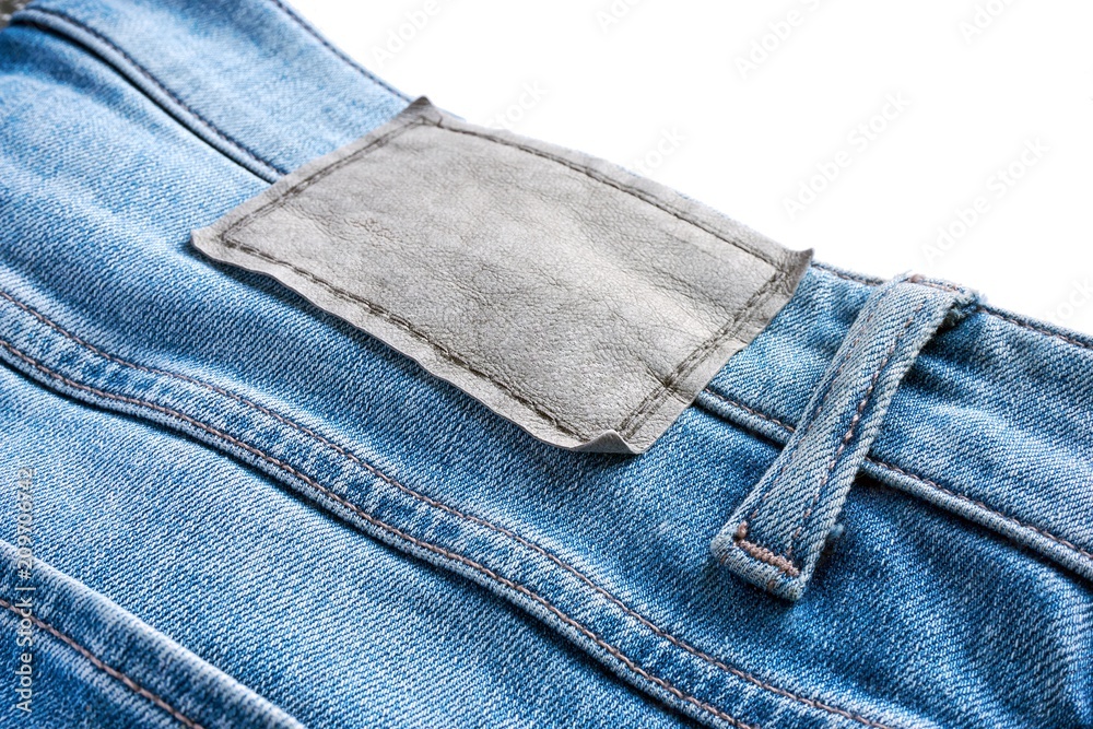 Close-up of blank leather label on blue jeans with belt loop isolated   