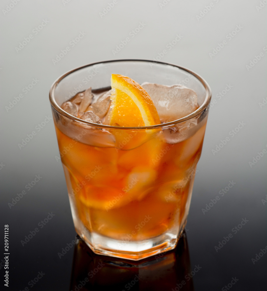 Closeup glass of negroni cocktail decorated with citrus on dark background. Closeup glass of negroni cocktail decorated with citrus on dark background.