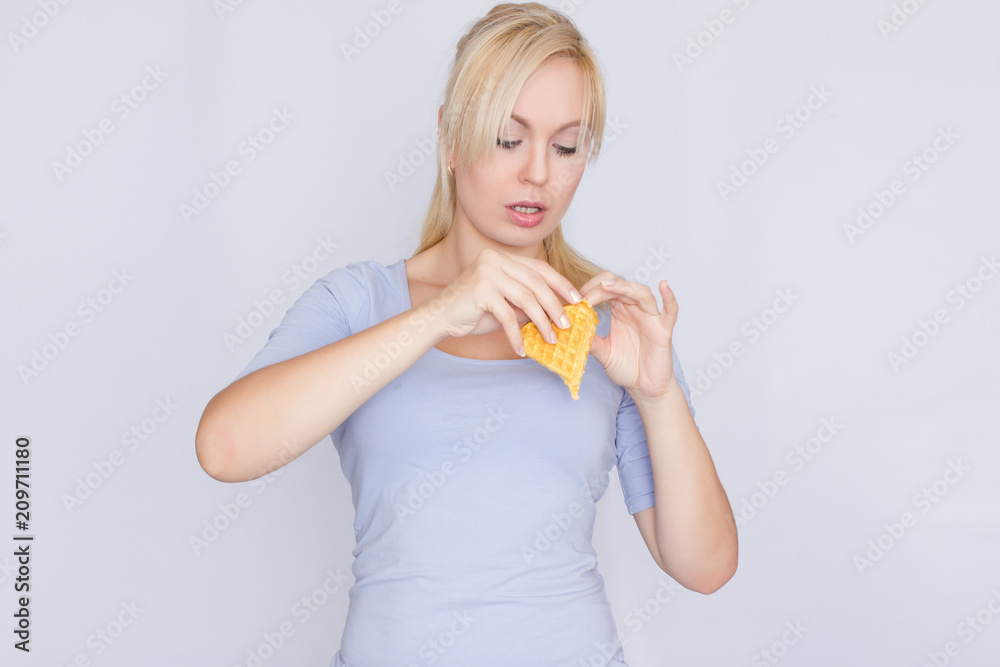 Happy blond woman holding in hands and showing belgian waffles Happy blond woman holding in hands and showing belgian waffles