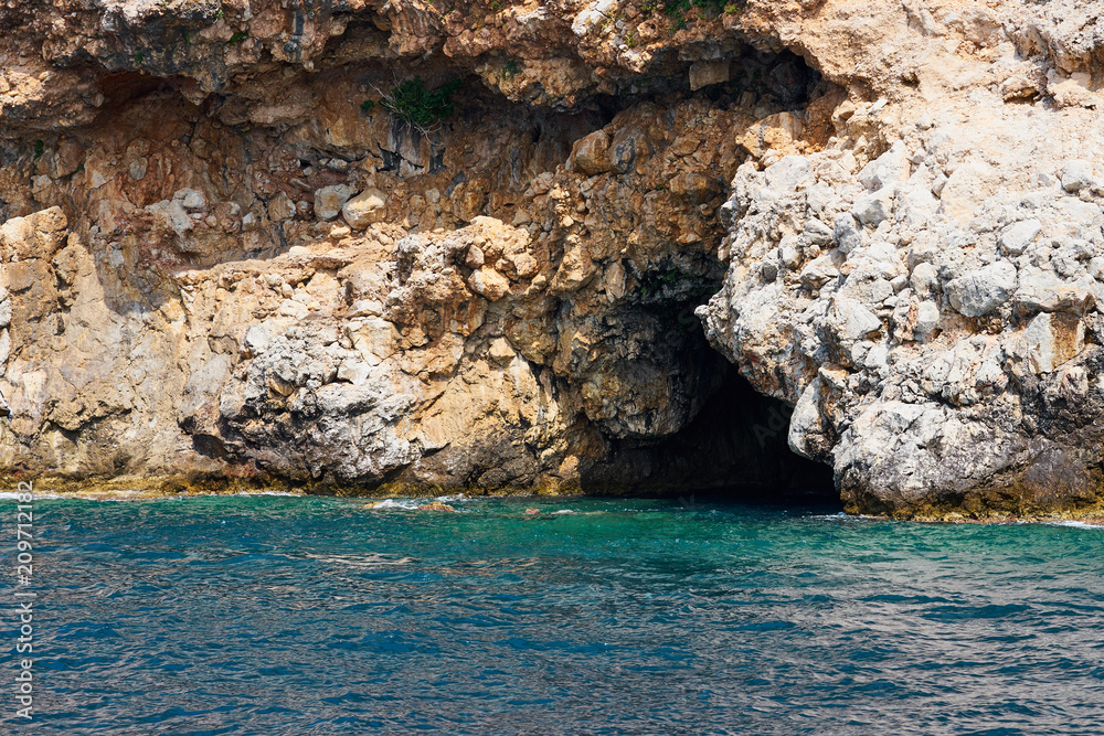 Cave at the bottom of sea cliffs. Alanya, Turkey.