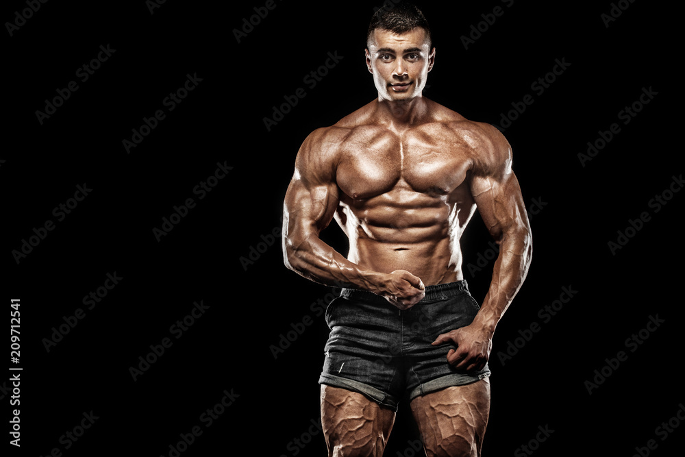Muscular young fitness sports man. Workout with dumbbell in fitness gym. Copy space for fitness nutrition ads.