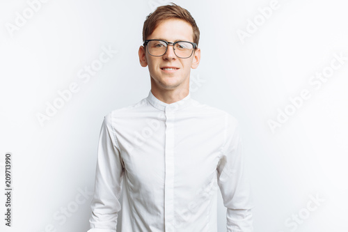 Obraz na plátně Portrait of young attractive guy in glasses, in white shirt, isolated on white b