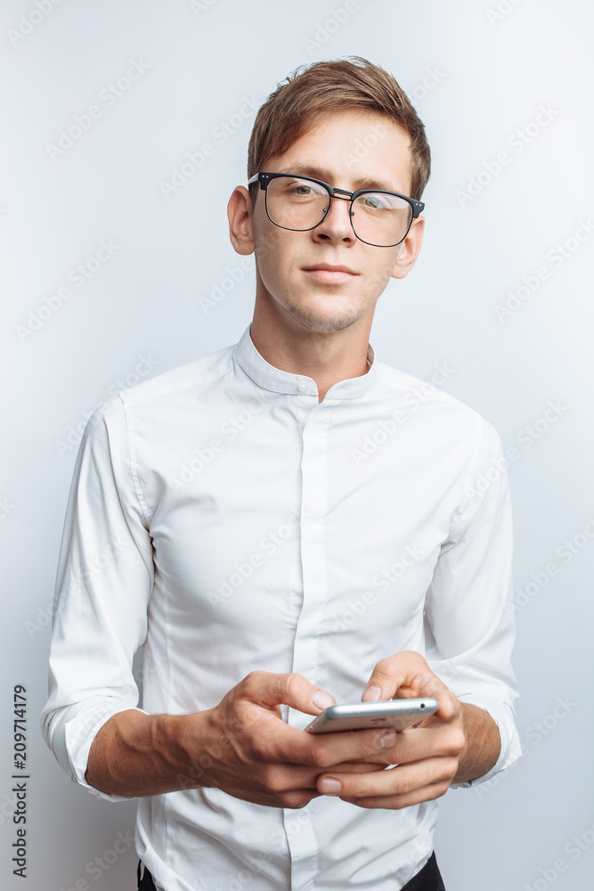 Image of a young guy with a phone, on a white background, for advertising, text insertion