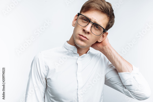Portrait of young attractive guy in glasses, in white shirt, isolated on white background, for advertising, text insertion photo